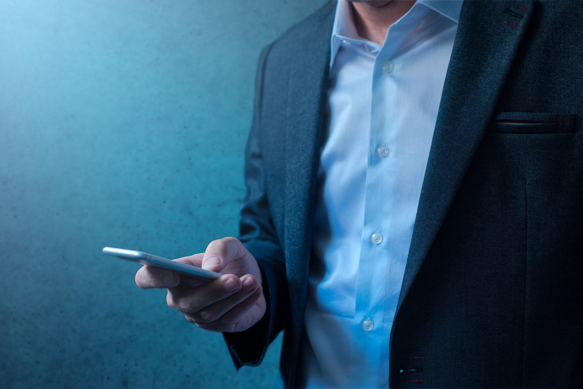 Handsome businessman in modern business suit using mobile phone